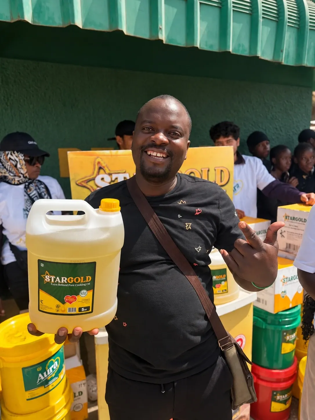 Team member holding a 5-litre Star Gold bottle at the product stand